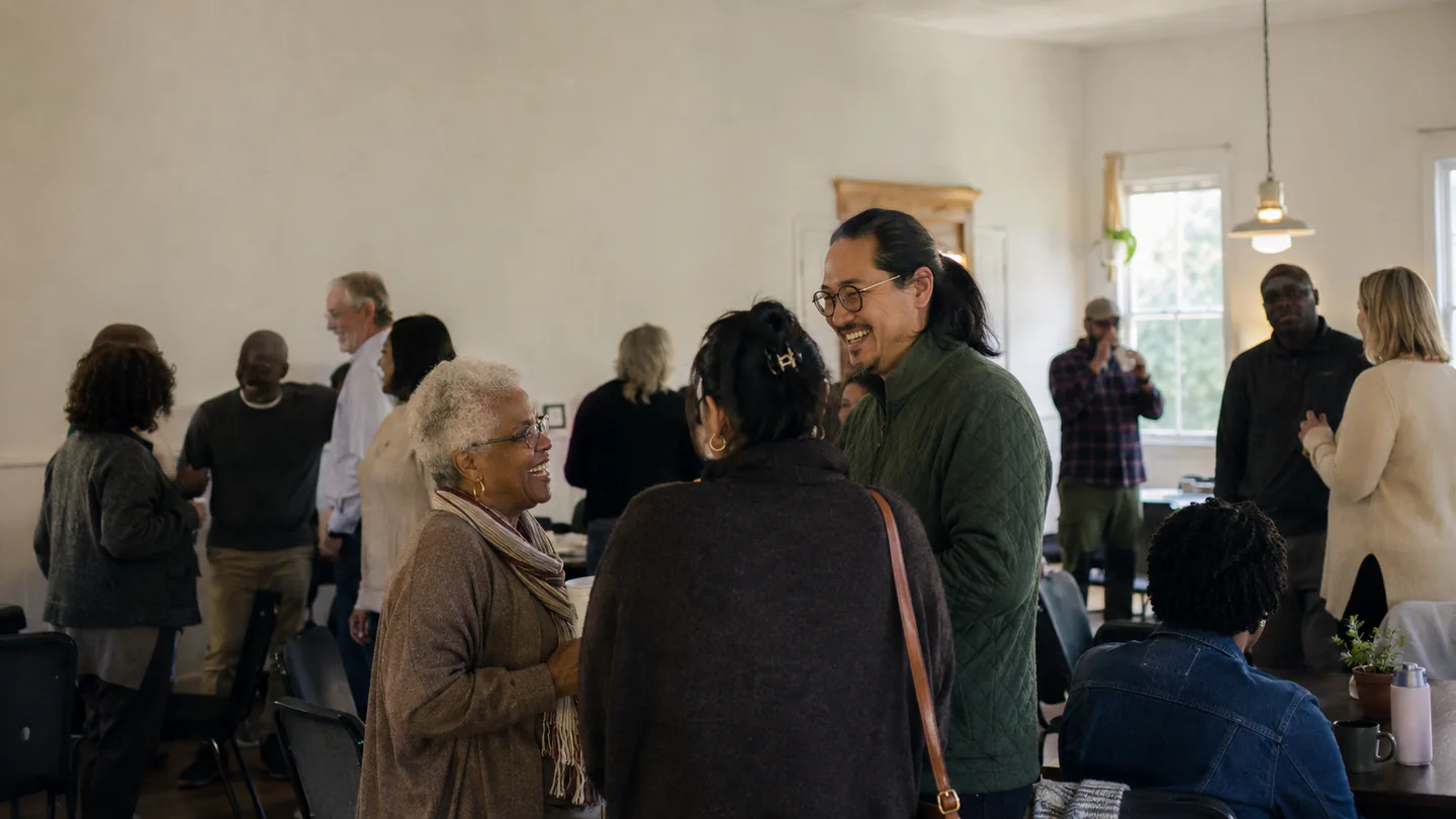 A broad, multigenerational church community gathering in conversation