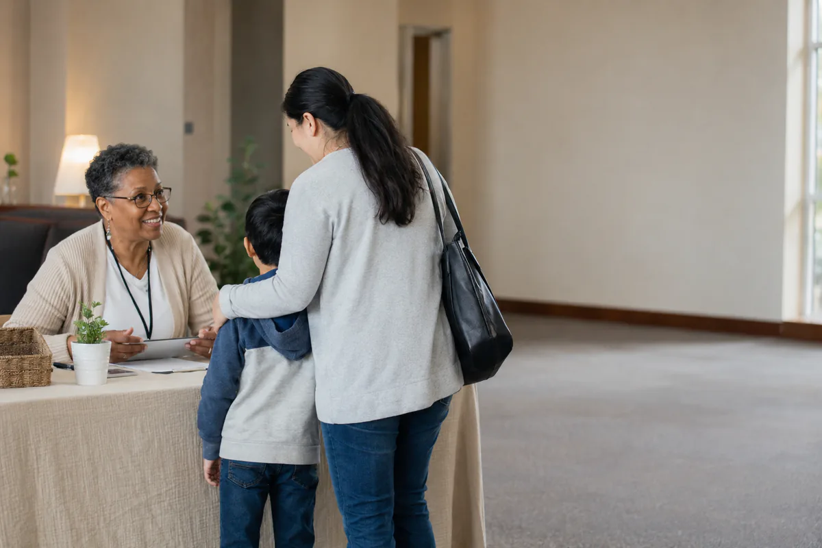 A volunteer welcoming a family at a church check-in table